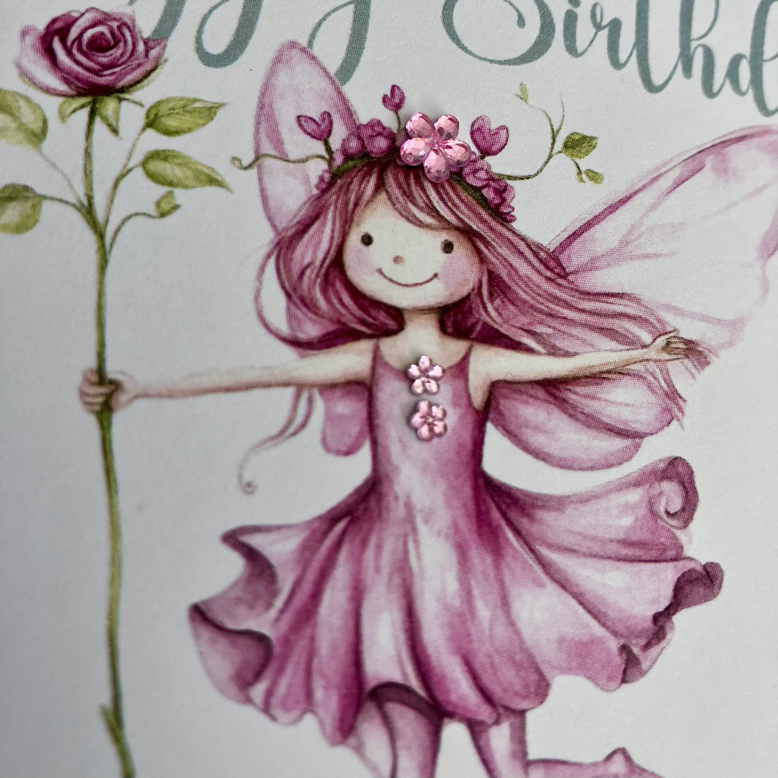 CLose up detail of a pretty pink fairy birthday card, personalised with name and embellished with diamanté gems